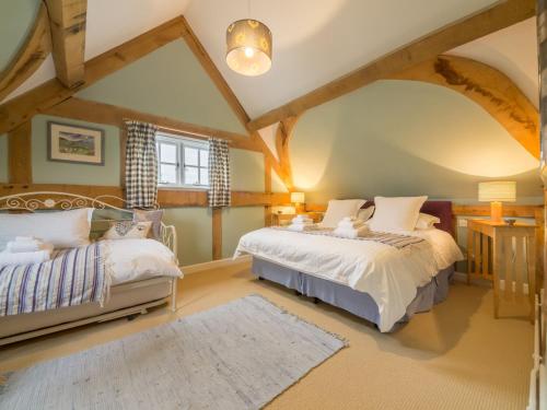 1 dormitorio con 2 camas y ventana en Bearwood Cottage en Pembridge