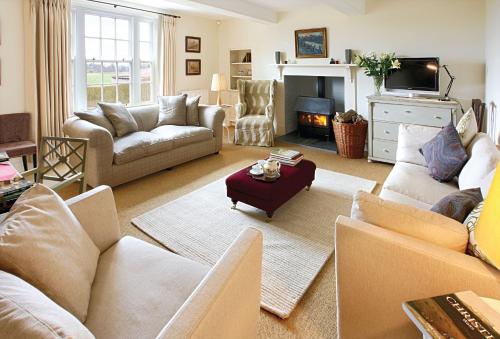 a living room with couches and a fire place at Upper Mowley in Kington