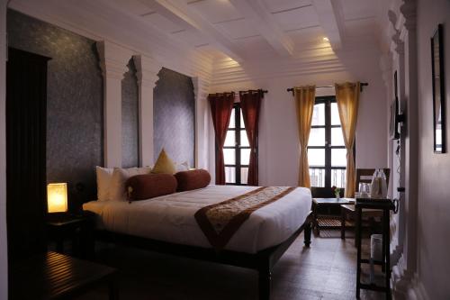 1 dormitorio con 1 cama y 2 ventanas en Le Chateau en Pondicherry
