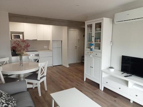 a living room with a table and a kitchen at SEAFRONT APARTMENT PINEDA BEACH in La Pineda