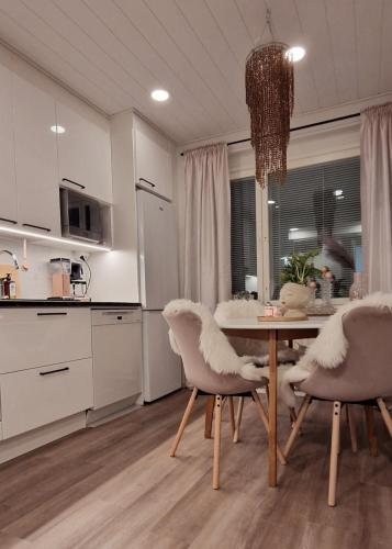 a kitchen with a table and chairs in a room at Huoneisto Olavinlinnan lähellä in Savonlinna
