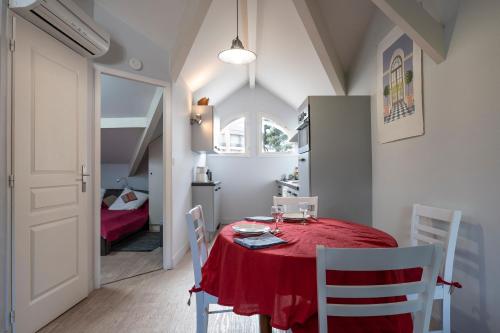 une salle à manger avec une table et des chaises rouges dans l'établissement Appartement Le Moulleau, à Arcachon