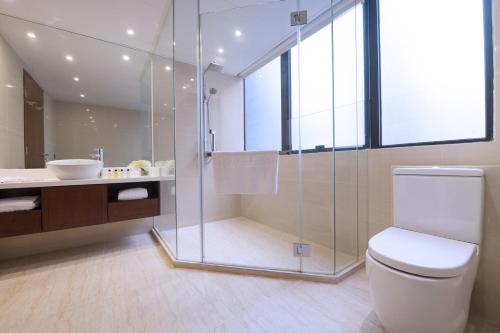 a bathroom with a shower and a toilet and a sink at Brighton Hotel Hong Kong in Hong Kong