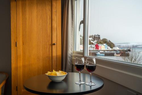 a table with two glasses of wine and a bowl of chips at Harbour Guest House in Tobermory
