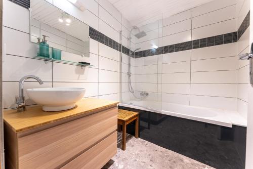 ein Badezimmer mit einem Waschbecken und einer Badewanne in der Unterkunft Le Crampon in Les Orres
