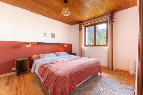 una camera con un letto con una parete rossa di Le Crampon a Les Orres