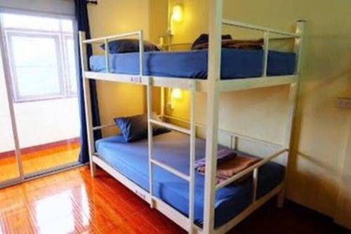 Ce dortoir comprend 2 lits superposés et une fenêtre. dans l'établissement 4Beds#Aircon#Mixeddorm#@Oldcity, à Chiang Mai