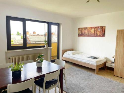 Habitación con mesa, cama y dormitorio. en Schickes Apartment in Offenbach am Main en Im Teller
