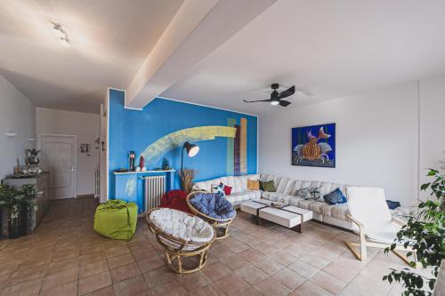 un soggiorno con divano bianco e parete blu di Sun62 a Porto Santo Stefano