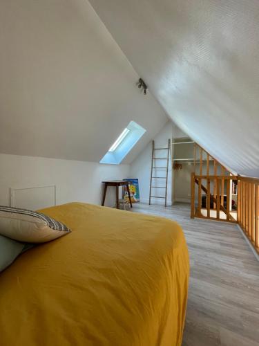a bedroom with a bed with a yellow blanket at A deux pas de la grande plage in Quiberon