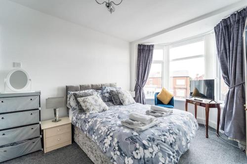 a bedroom with a bed and a desk and a window at Birkdale boutique Apartment in Southport