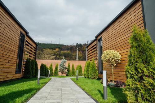 a walkway between two buildings with trees at Telegdy Homes in Praid