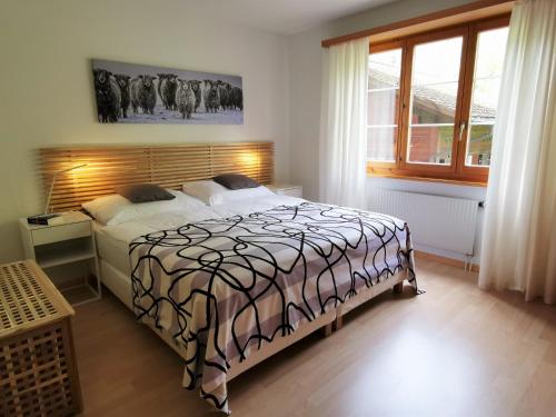 a bedroom with a bed with a black and white comforter at Hotel Brienzersee in Ringgenberg