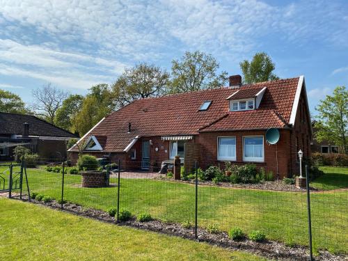 una casa con una valla en el patio en Ferienhaus Huus up Polder 65349, en Moormerland