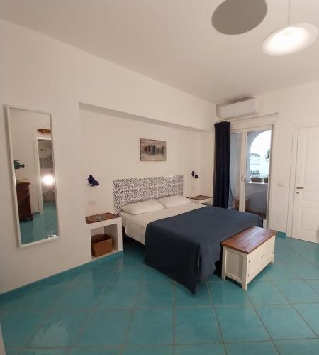 a bedroom with a bed and a table and a window at La Casa Di Massimiliano - Villa del Sole in Capri