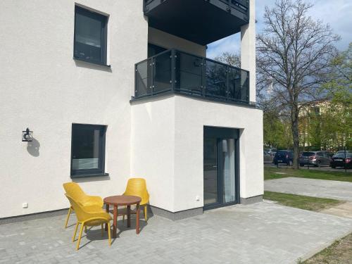 2 chaises et une table en face d'un bâtiment dans l'établissement Spree Chalet Cottbus, à Cottbus