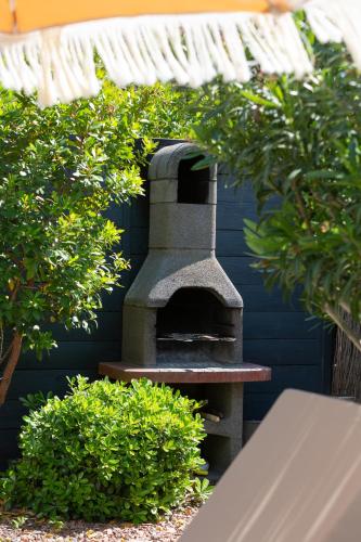 a stone oven in the middle of a garden at Villas les Capucines in Sète