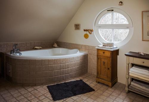 uma casa de banho com uma banheira grande e uma janela no sótão em PTASIE SZEPTY em Głosków