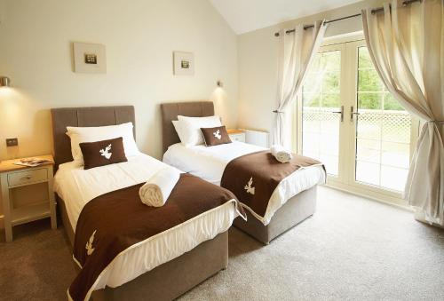 um quarto com 2 camas e uma janela em Ramson Lodge em Chappel