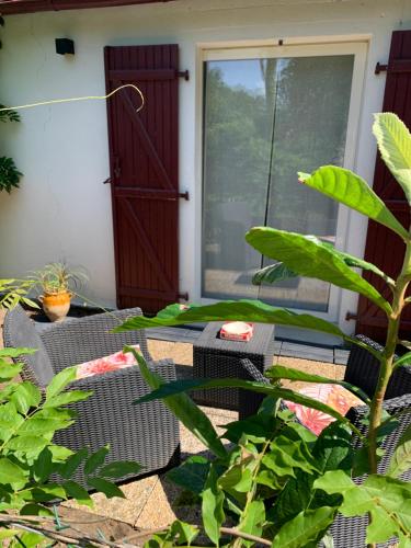 a patio with a table and chairs in front of a door at Studio à Linxe entre terre et océan in Linxe