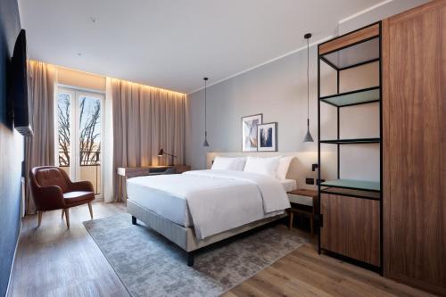 a bedroom with a bed and a desk and a chair at Radisson Hotel Ferrara in Ferrara