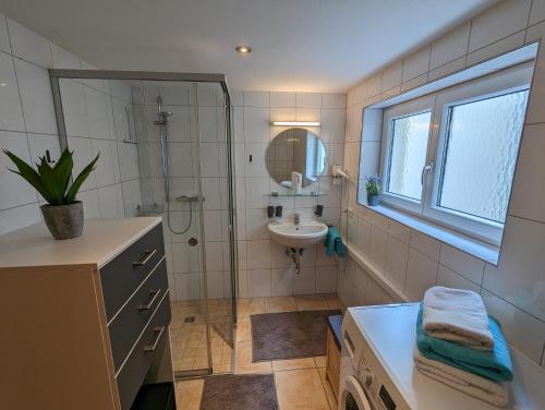 a bathroom with a shower and a sink and a mirror at Ferienwohnung Apimundi in Lauterach