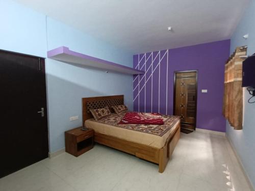 a bedroom with a bed with a purple wall at Karpagam Residency in Ooty