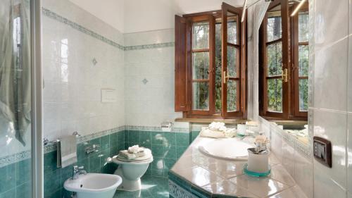 a bathroom with two sinks and a toilet at VILLA NIKKA 6, Emma Villas in Riparbella