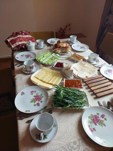 une table avec des assiettes de nourriture et de fromage dans l'établissement Dilbo House, à Dilidjan