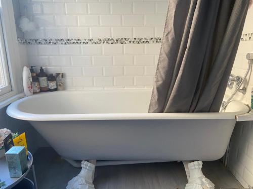 a white bath tub with a shower curtain in a bathroom at Mid City Charm - 1-Bed Apartment in London in London