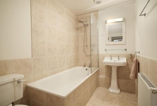 a bathroom with a bath tub and a sink at Courtyard House in Kelso