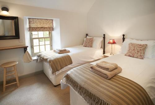 a bedroom with two beds and a window at Courtyard House in Kelso