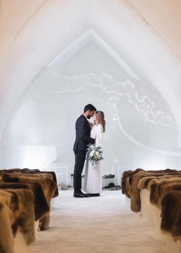a bride and groom kissing in a chapel at Arctic SnowHotel & Glass Igloos in Sinettä