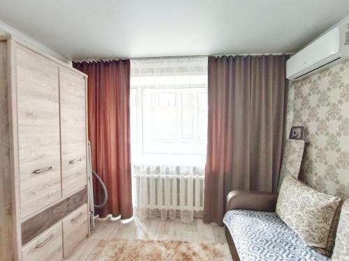 - une chambre avec un lit et une grande fenêtre dans l'établissement Люксовые апартаменты в Центре г.Семей, à Semey