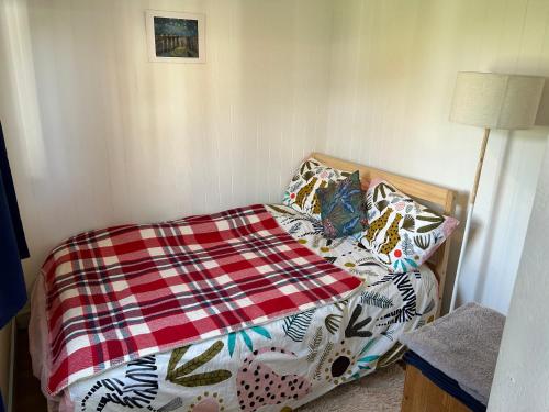 a bed with a blanket on it in a room at Mini cabin in Zone 2 in London