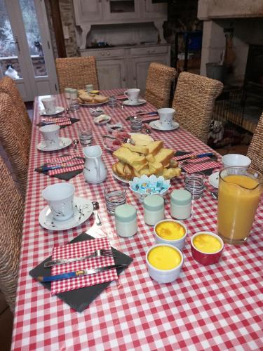 une table avec un chiffon de table rouge et blanc dans l'établissement LES 2 CHENES, à Les Riffes
