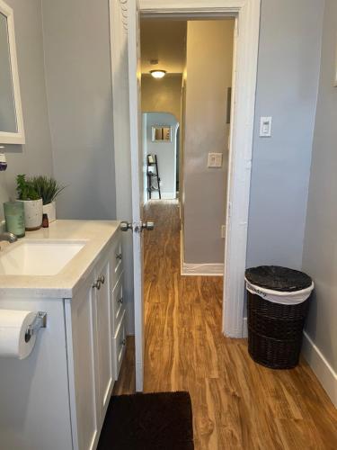 a bathroom with a sink and a door to a hallway at 2bed 1bath close to downtown LB, LA and OC. in Long Beach