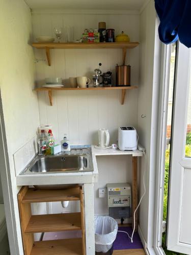 a kitchen with a sink in a small room at Mini cabin in a quiet area in London