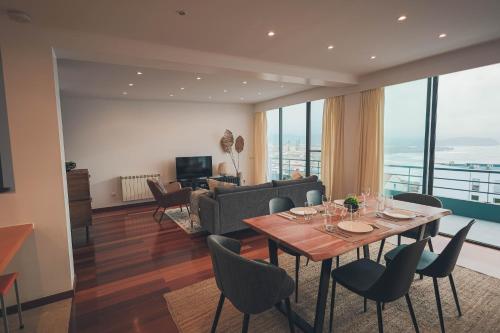 a living room with a table and chairs at Ribeira Grande Ocean View Apartment in Ribeira Grande