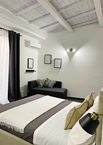 ein Schlafzimmer mit einem Bett und einem Sofa in der Unterkunft La casa di Eva in Avola