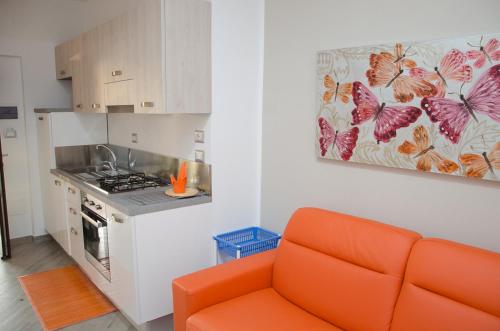 an orange couch in a kitchen with a painting on the wall at La Rosa Dei Venti in Acciaroli