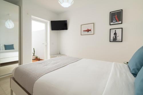 アレシーフェにあるSabbia Suites Casa Ninaの白いベッドルーム(大型ベッド1台、窓付)