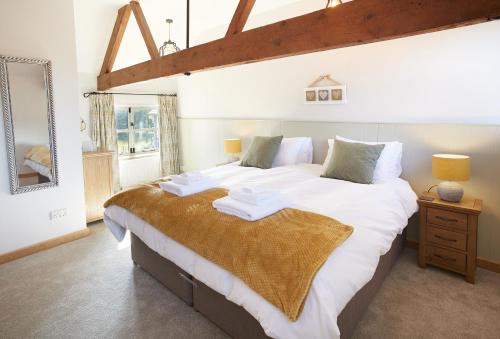 a bedroom with a large bed with white sheets at Pear Tree Cottage Shropshire in Orleton
