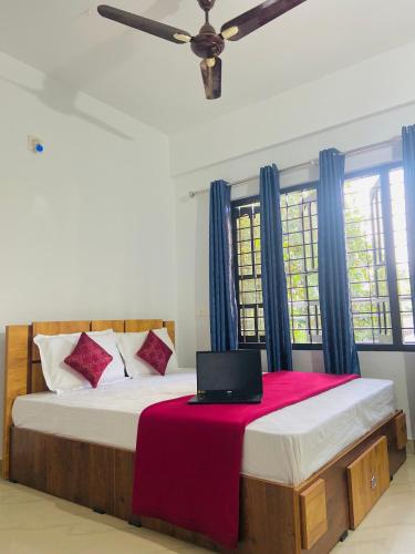 a bedroom with a bed with a laptop on it at Green Line Homestay in Vythiri