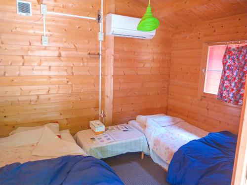 um quarto com 2 camas num chalé de madeira em 星逢える宿ー森のコテージ気仙沼 em Kesennuma