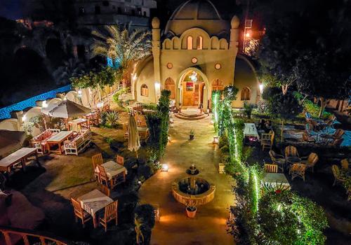 an aerial view of a building with a fountain and tables at Embrace Hotel in Luxor