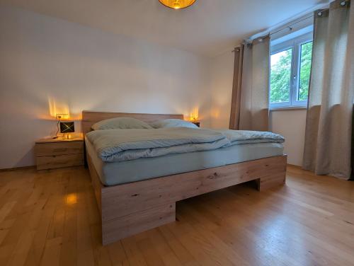 a bedroom with a bed and a large window at Ferienwohnung Apimundi in Lauterach