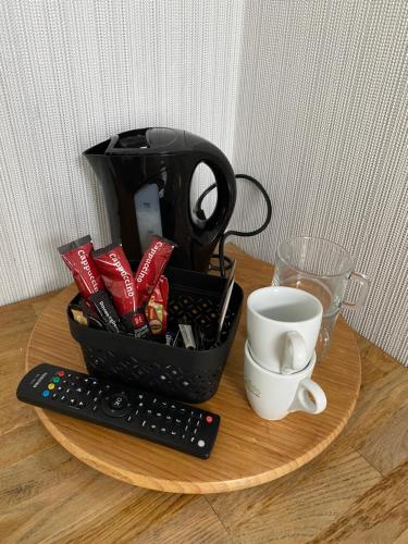 uma xícara de café e um controle remoto sobre uma mesa em Het Wapen van Aelden em Aalden