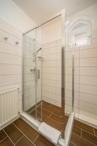 a shower with a glass door in a bathroom at Tokajer Wellness Panzió in Keszthely