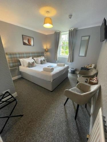 a bedroom with a bed and a chair in it at Isle of Skye Guest House in Kyleakin
